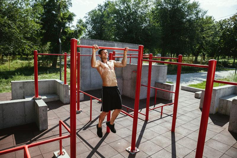 man doing pullups at a calisthenics gym